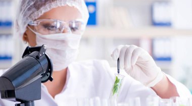 Bir laboratuarda deney yapan kadın bir bilim adamı.