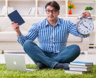 Genç yakışıklı adam evde yerde oturuyor.