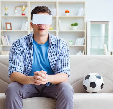 Sanal gerçeklik gözlüğü takan bir adam futbol maçı izliyor.