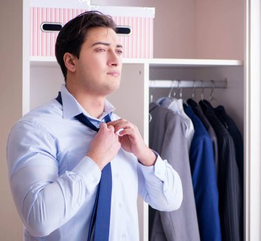 Genç işadamı iş için giyiniyor.