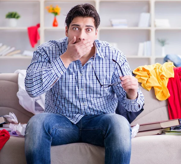 Joven trabajando estudiando en una habitación desordenada — Foto de Stock