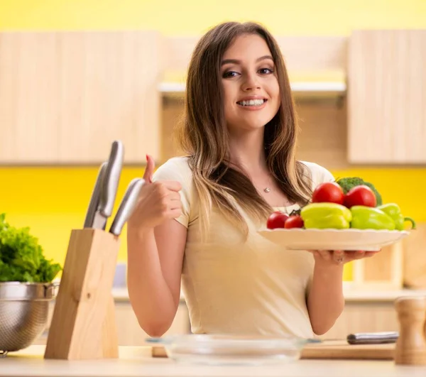 Junge Frau bereitet Salat zu Hause in Küche zu — Stockfoto