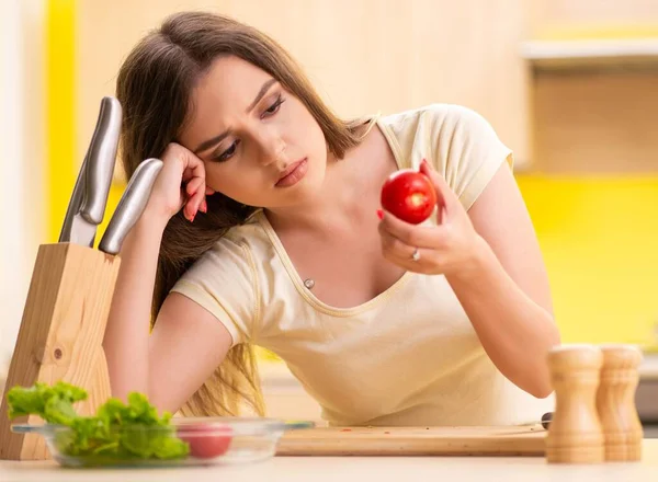 Jovem mulher preparando salada em casa na cozinha — Fotografia de Stock