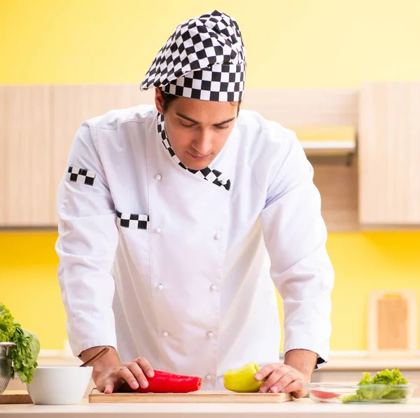 Young professional cook preparing salad at home — Stock Photo, Image