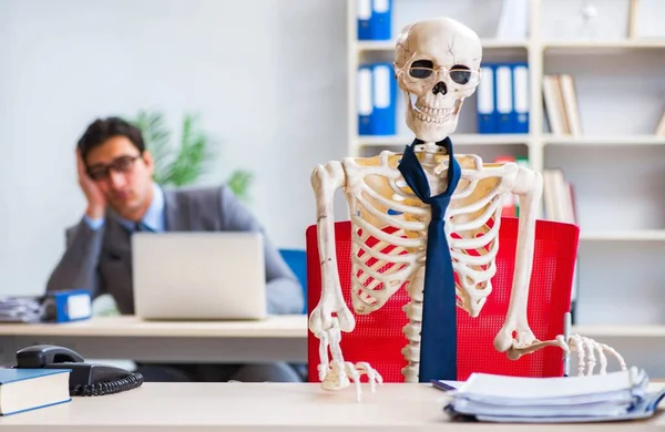 Businessman working with skeleton in office — Stock Photo, Image