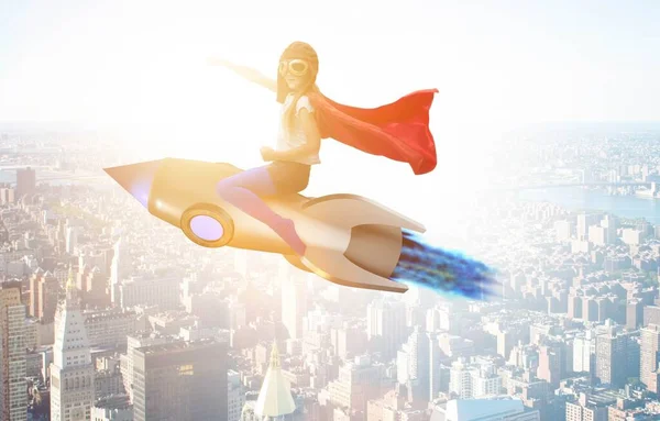 Niña volando cohete en concepto de superhéroe — Foto de Stock