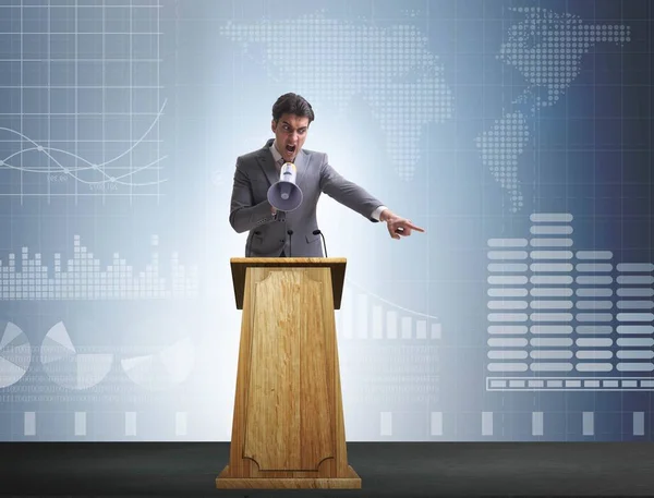 Hombre de negocios haciendo discurso en la tribuna en el concepto de negocio —  Fotos de Stock