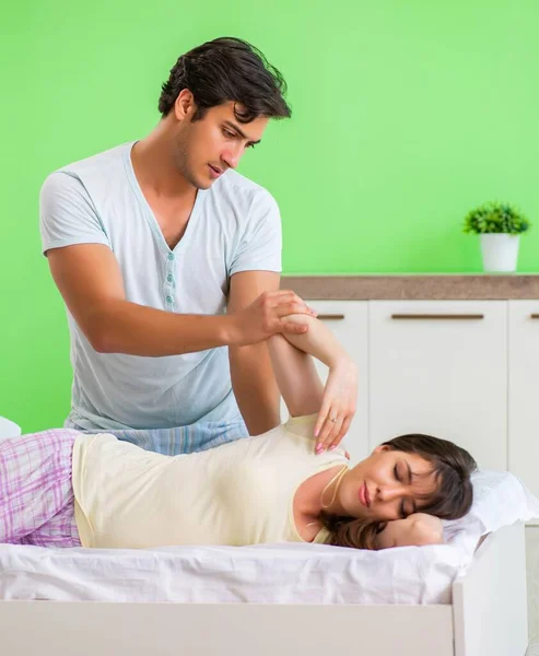 Mann tut Massage für seine Frau im Schlafzimmer — Stockfoto