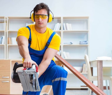 Tamirci marangoz. Dolaşım halindeki tahta testereyi kesiyor.