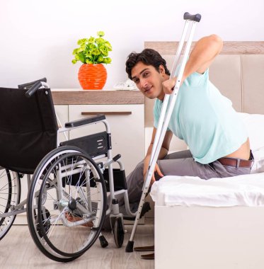 Genç yakışıklı engelli adam evde iyileşiyor.