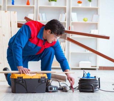 Genç marangoz tahta kalaslarla çalışıyor.