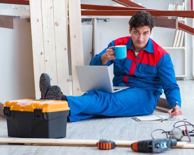 Dizüstü bilgisayarı olan genç marangoz.