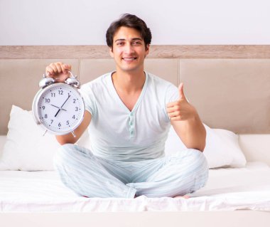 Genç adam yatak odasında yoga yapıyor.