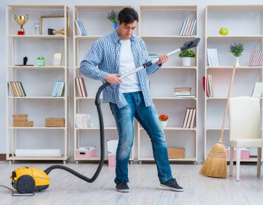 Adam evi temizliyor.