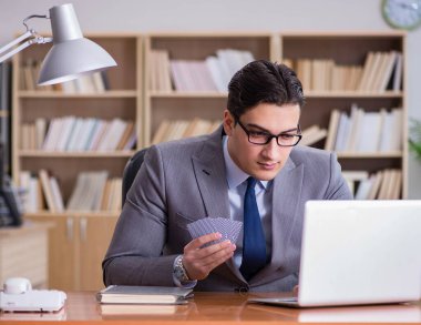 İşadamı iş yerinde kumar oynuyor.