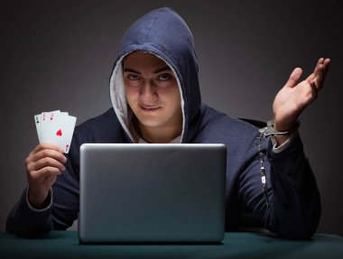 Elleri kelepçeli kapüşonlu genç bir adam Los Angeles 'ın önünde oturuyor.