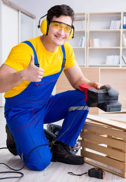 Reparador carpinteiro polir uma placa de madeira com um po elétrico — Fotografia de Stock