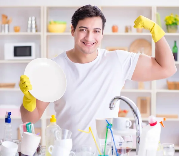 Buen marido lavando platos en casa — Foto de Stock