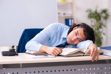 İş yerinde okuyan genç bir işadamı.