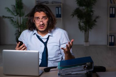 Genç işadamı ofiste geç saatlere kadar çalışıyor.