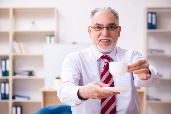 Vieil employé masculin profitant du café pendant la pause café — Photo