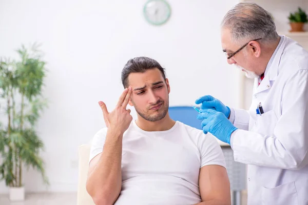 Jongeman op bezoek bij ervaren arts dermatoloog — Stockfoto