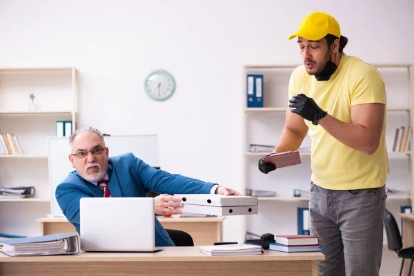 Giovane corriere maschio consegna pizza in ufficio — Foto Stock