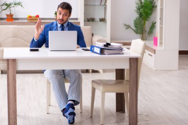 Evden kendini izole etme konseptiyle çalışan genç bir erkek işçi.