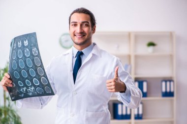 Klinikte çalışan yakışıklı genç bir doktor.