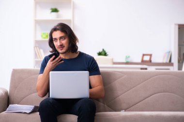 Evden çalışan genç bir adam.