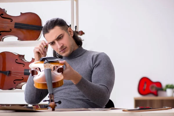 Jeune réparateur masculin réparant violon — Photo