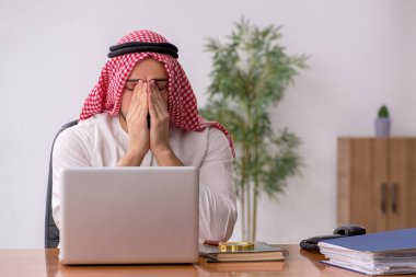 Ofiste çalışan genç bir Arap erkek.