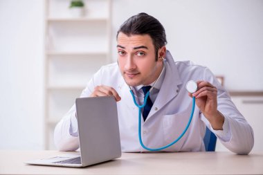 Steteskopu tamir eden genç bir erkek doktor.