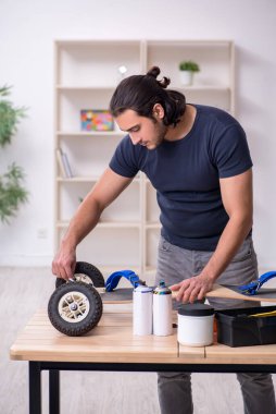 Kaykay tamir eden genç bir erkek tamirci.