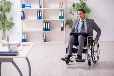 Tekerlekli sandalyede çalışan genç bir erkek.