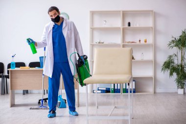 Genç erkek müteahhit salgın konseptinde dezenfekte kliniği