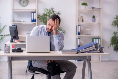 Ofiste çalışan genç bacağı yaralı bir çalışan.