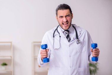 Klinikte çalışan genç erkek doktor.