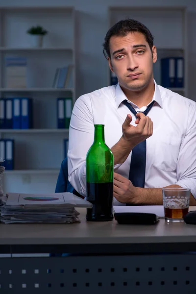 Alcohol verslaafde zakenman die laat op kantoor werkt — Stockfoto