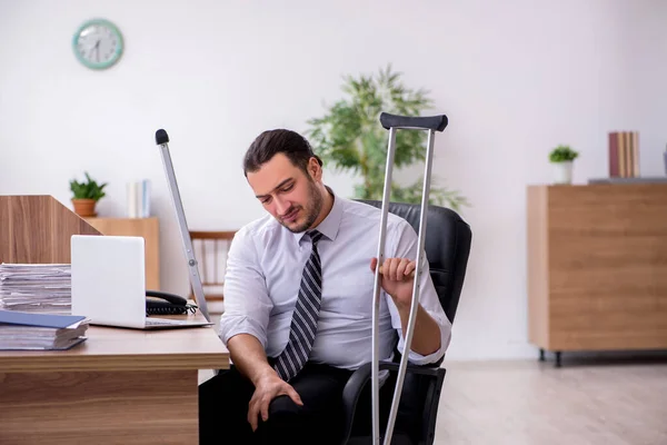 Jeune employé blessé à la jambe souffrant sur le lieu de travail — Photo