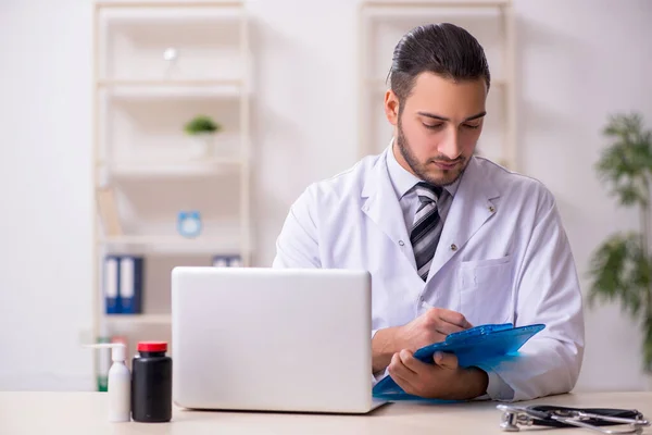 Ung manlig läkare som arbetar på kliniken — Stockfoto