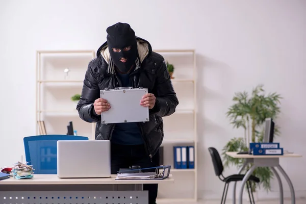 Junger männlicher Einbrecher im Büro — Stockfoto