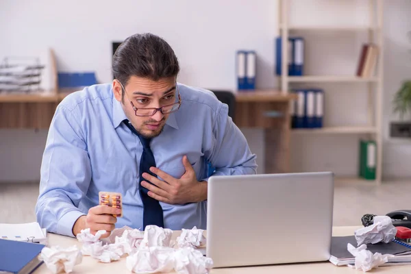 Zieke mannelijke werknemer die op het werk lijdt — Stockfoto