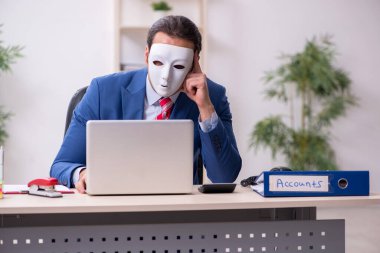 İkiyüzlülük konseptinde maske takan erkek çalışan.