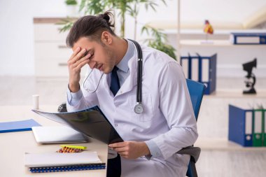 Klinikte çalışan genç erkek doktor.