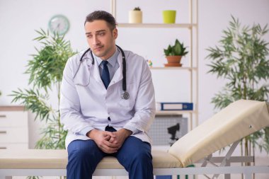 Klinikte çalışan genç erkek doktor.