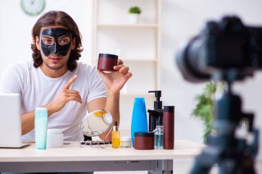 Genç erkek kozmetikçi blogu için video kaydediyor.