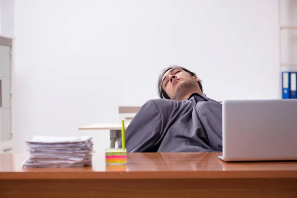 Ung manlig anställd sover på kontoret — Stockfoto