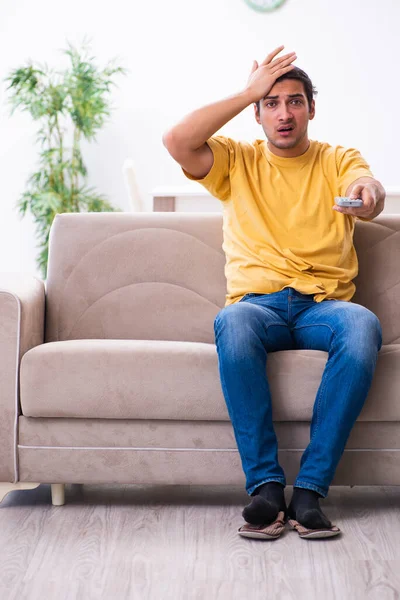 Hombre joven viendo la televisión en casa — Foto de Stock