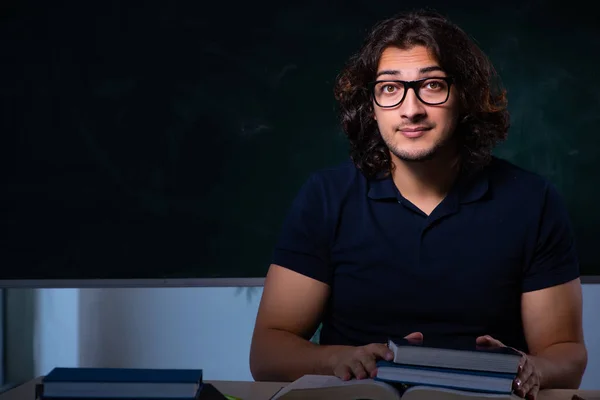 Young male student in the classroom at night — Stock Photo, Image